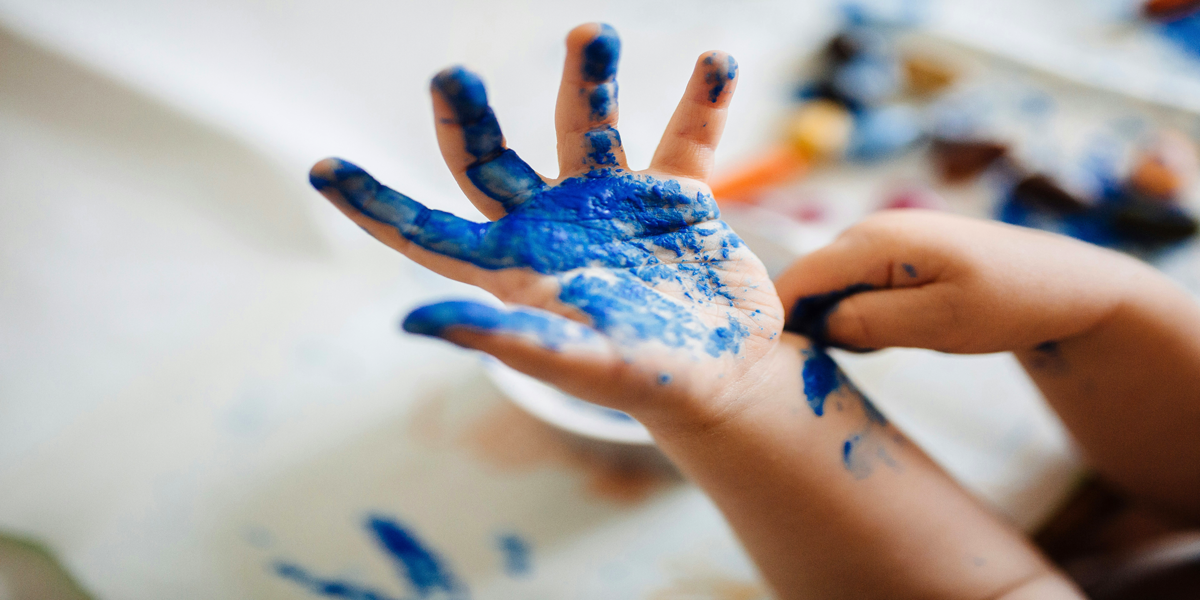 Blue paint on kid's hand.