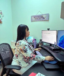 Woman working at a computer with double screens.